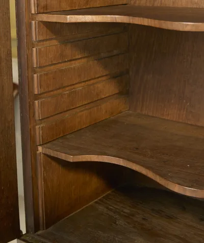 Shaped shelves resting on toothed side supports inside the upper cabinet, cut to sit at different heights.