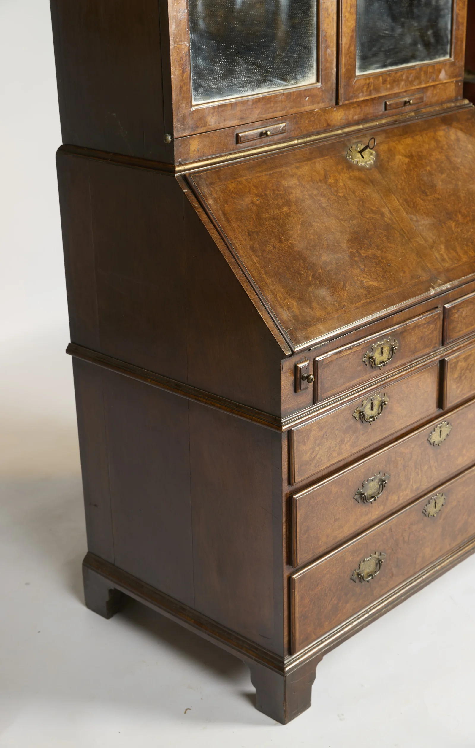 The case seen from the left, plain-panelled at the side, with a key sitting in the shaped fall escutcheon.