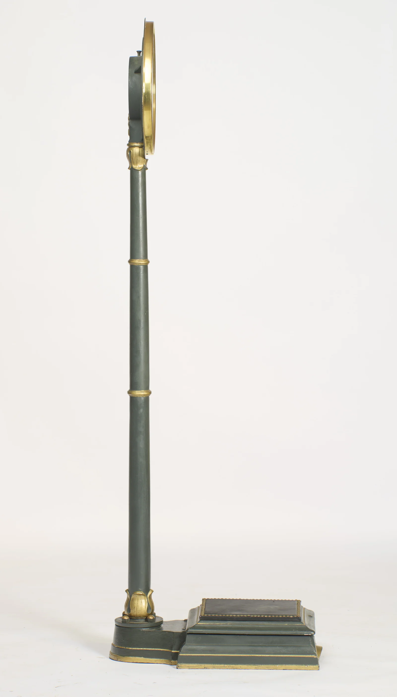 In profile the column rises with a slight backward rake, the dial edge-on above and the platform extending to the side.