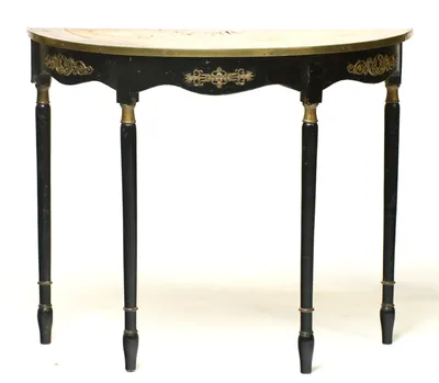 The brass-bound top above a shaped black frieze applied with pierced gilt-metal mounts, raised on four slender ring-turned legs with gilt collars.