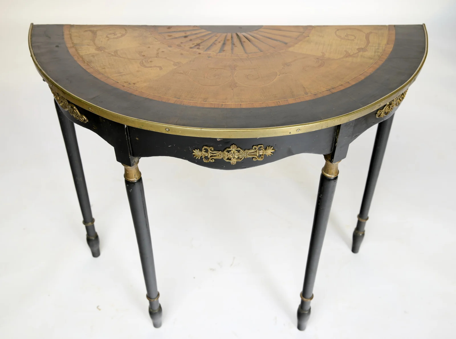 The semicircular top opens up to show the radiating fan centre, the scrolling leaf inlay and the broad dark border inside the brass rim.