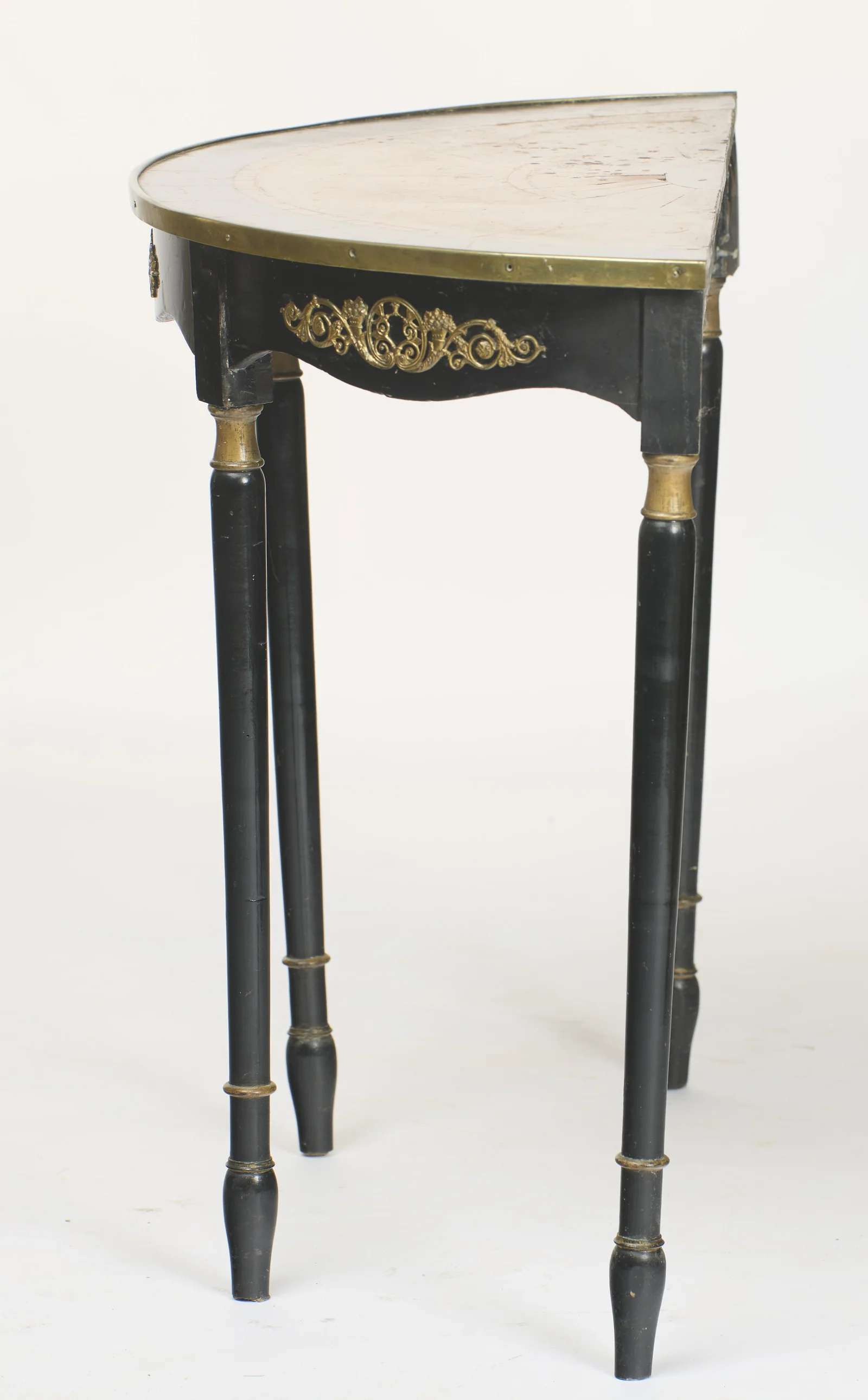 Seen from the end, the top reads at its full depth, the brass edge running back to the straight rear rail and the legs standing in line.