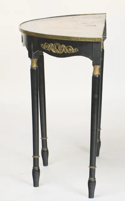 Seen from the end, the top reads at its full depth, the brass edge running back to the straight rear rail and the legs standing in line.