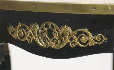 A pierced scrolling mount with flower-filled cornucopias and rosettes, the tall gilt collars of the flanking legs visible below.