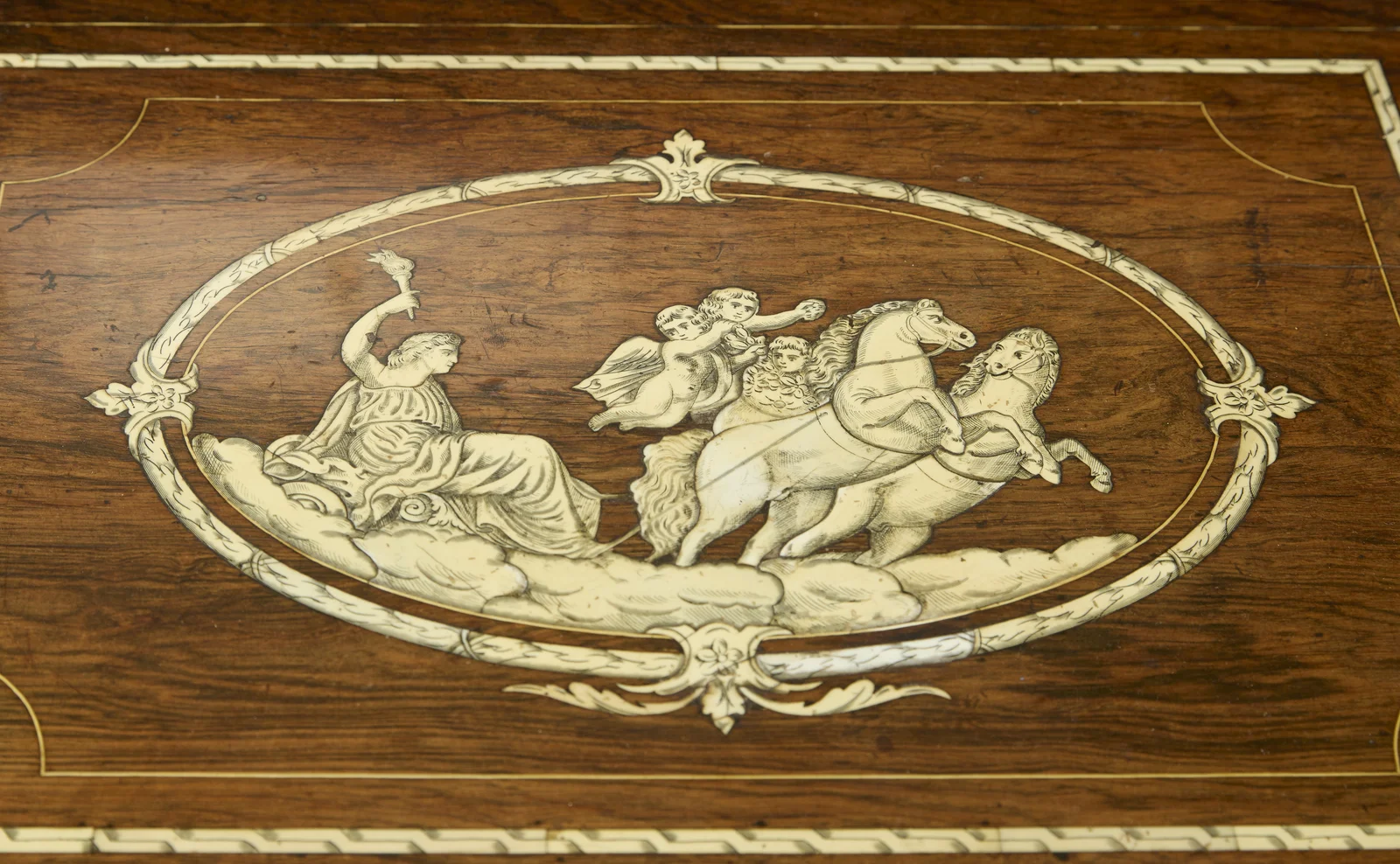 The oval medallion set in a rectangular reserve within chevron-engraved banding, the back panel of the recess inlaid with a two-handled urn between ribbon-hung swags and drop pendants.