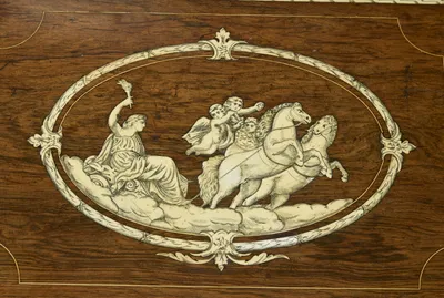 An oval laurel band enclosing a draped figure raising a torch, carried on clouds behind two rearing horses with winged child attendants; fine cracks run across the engraved panel.
