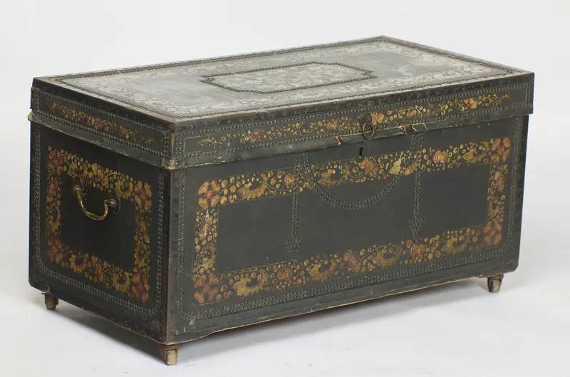 Painted and close-studded leather-covered trunk with swan-neck end handles, on castors