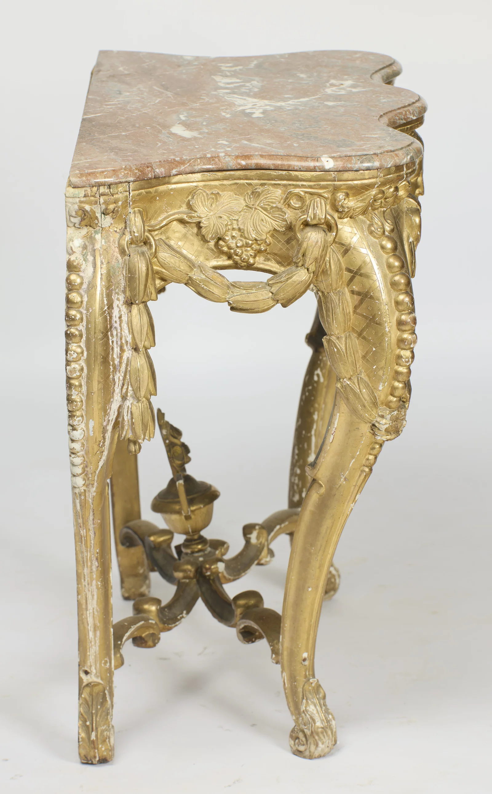 The side frieze has its own grape cluster within a looped swag, and the back edge is flat for standing against a wall.