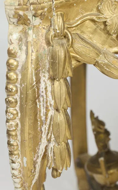 Flaking along the beaded edge has exposed the white ground, while the drop husks beside it remain crisp.