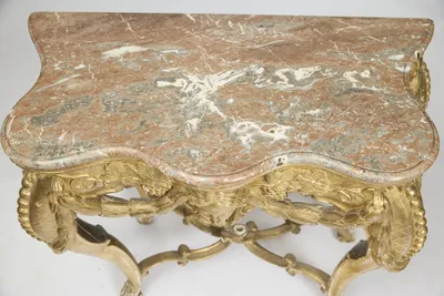 Rose-pink stone mottled with grey and broken by broad white veins, the moulded edge following the serpentine outline.