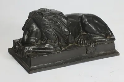 Deep flowing locks over the head and shoulder, the eye half closed beneath a heavy brow, the muzzle sunk onto the forepaws.