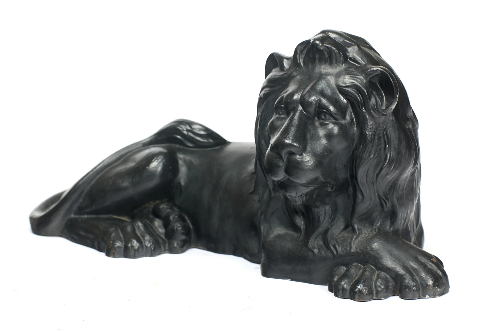 The head turned above outstretched forepaws, the mane in long waved strands down the chest.