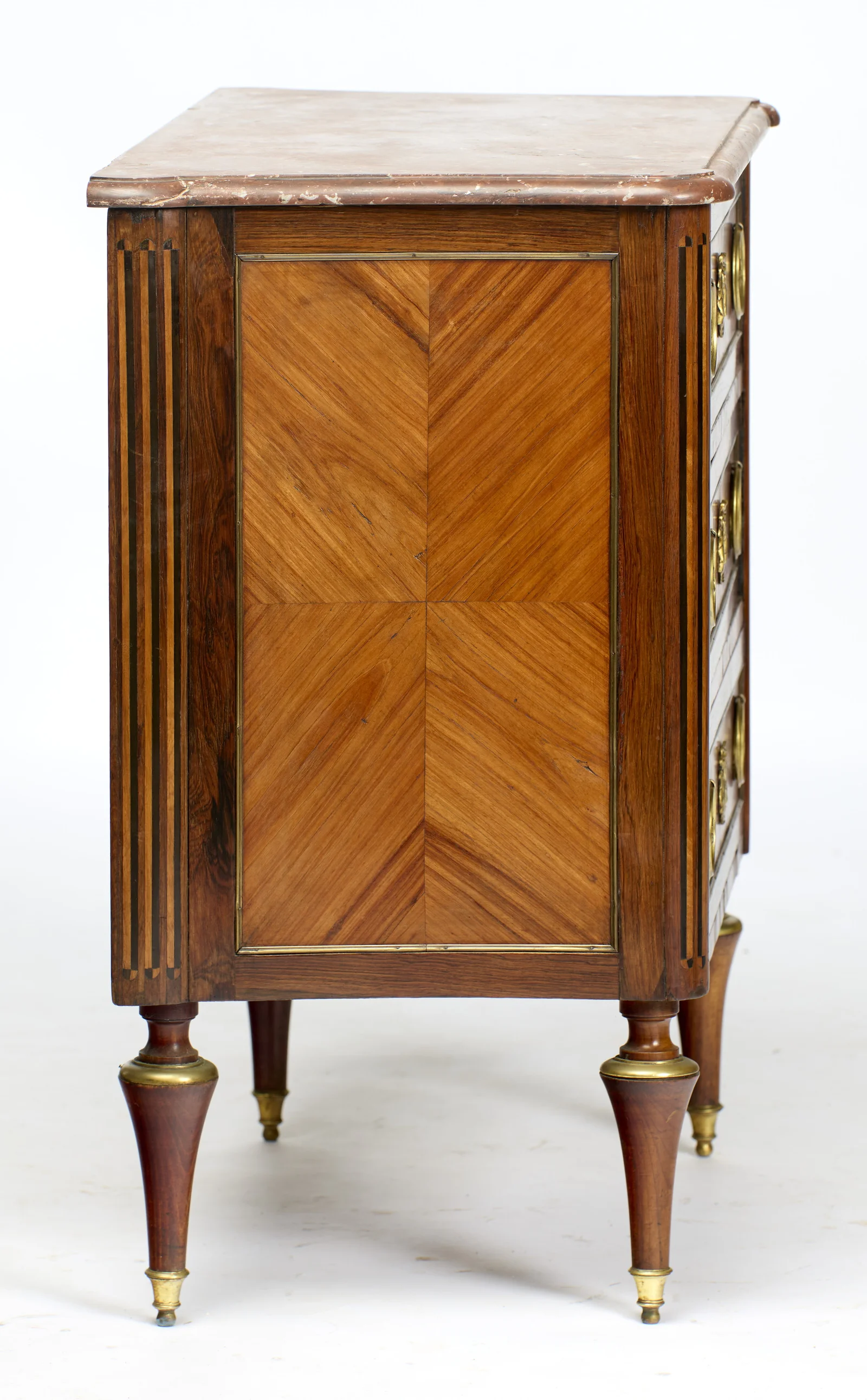 A book-matched panel of four veneers framed in gilt-metal, flanked by inlaid flutes; small losses show along the front edge of the marble above.