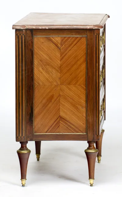 A book-matched panel of four veneers framed in gilt-metal, flanked by inlaid flutes; small losses show along the front edge of the marble above.