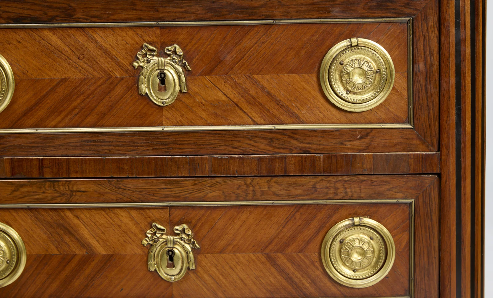 The moulded marble edge above the top drawer, with pressed rosette handle, ribbon escutcheon and the light and dark flutes of the canted corner.
