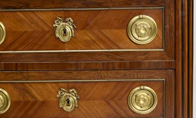 The moulded marble edge above the top drawer, with pressed rosette handle, ribbon escutcheon and the light and dark flutes of the canted corner.